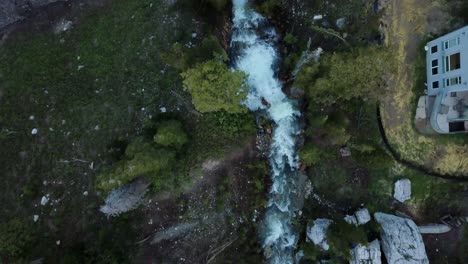 Overhead-flight-over-a-running-river-during-spring-run-off-in-a-canyon-at-the-close-of-skiing-season