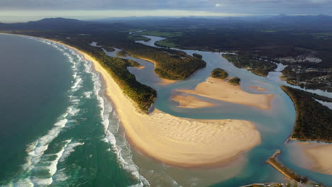 Wide-revealing-drone-shot-of-Foster-beach,-the-Nambucca-River-and-ocean-at-Nambucca-Heads-New-South-Wales-Australia