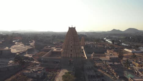 Top-view-of-Virupaksha-Temple-amidst-near-the-banks-of-Tungabhadra-River-in-Hampi,-India---Aerial-Orbit-Point-of-interest-shot