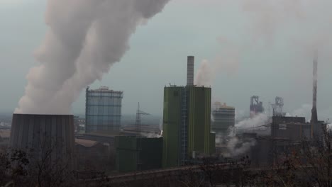 Steam-rising-from-cooling-tower-at-large-German-steel-factor-in-Duisburg-NRW