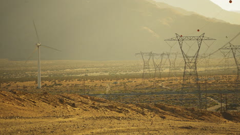Steady-wide-view-of-wind-turbines-and-high-voltage-transmission-lines-at-a-wind-farm-near-Palm-Springs-in-the-Mojave-Desert,-California,-USA