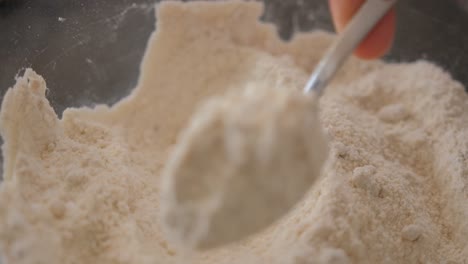 Close-up-of-taking-a-spoonful-of-flour-out-of-a-bowl