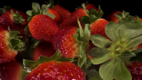 Makroansicht,-Die-Erdbeeren-Auf-Schwarzem-Glas-Dreht,-4k-aufnahme-Von-Gesundem-Frischem-Obst,-Ernährung,-Rote-Erdbeere