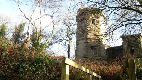 Abandoned-Autumn-woodland-watchtower-stone-castle-keep-building-in-rural-English-countryside-low-right-dolly