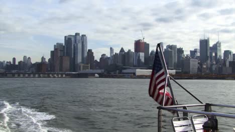 Downtown-Manhattan-skyline-from-the-ferry-tour-and-the-USA-flag