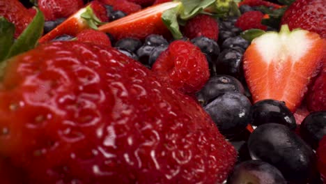 Makroansicht-über-Eine-Auswahl-An-Beeren-Auf-Schwarzem-Hintergrund,-4k-Aufnahme-Von-Gesundem-Frischem-Obst,-Ernährung,-Heidelbeeren,-Himbeeren-Und-Erdbeeren