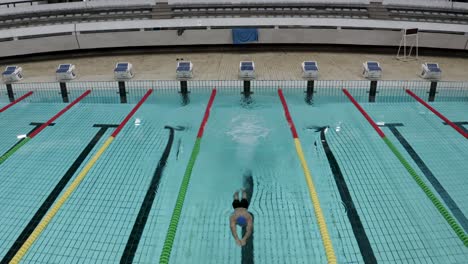 Ein-Mann,-Der-In-Einem-Olympischen-Schwimmbad-Auf-Das-Wasser-Springt