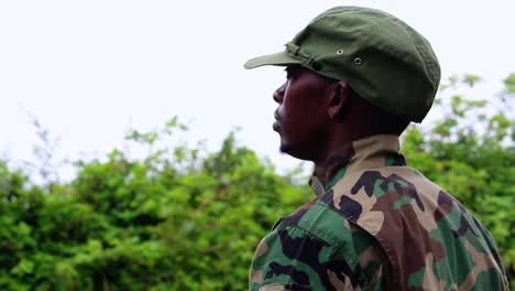 African-soldier-standing-still-waiting-for-order-in-forest,-overcast-day