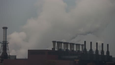 Industrial-chimneys-at-a-power-plant-releasing-white-smoke-in-the-air