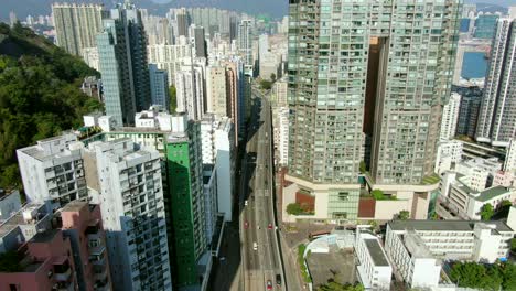 Toma-Aérea-De-Mega-Rascacielos-Residenciales-Y-Tráfico-En-El-Centro-De-Hong-Kong,-En-Un-Hermoso-Día