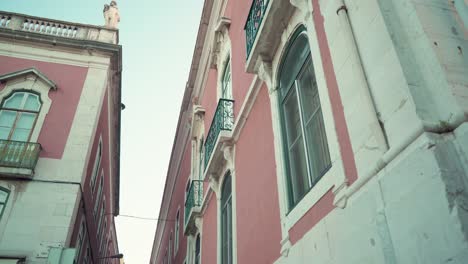 Lisbon-typical-street-facade-with-big-windows-at-dawn-in-low-angle-traveling-shot