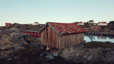 Typical-nordic-wooden-red-cottage-in-a-fisherman-village-near-the-seaside-with-no-people-around,-panning-shot,-travel-concept