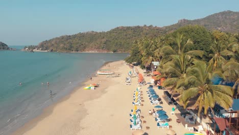 Aerial-4k-drone-footage-of-visitors-at-a-tropical-beach-in-Palolem,-India