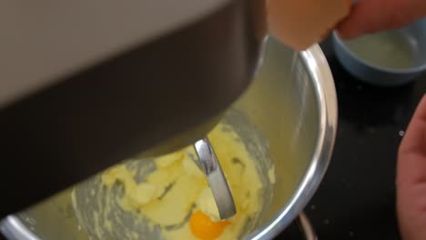 Slow-motion-adding-an-egg-yolk-to-a-recipe-in-a-mixing-bowl