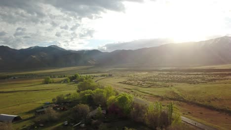 The-sun-rises-over-a-green-mountain-valley-over-a-ranch
