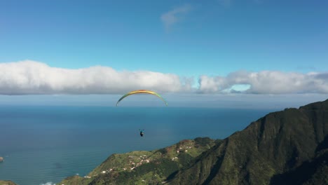 Aerial-of-paraglider-soaring-through-air-above-scenic-mountains-of-Madeira
