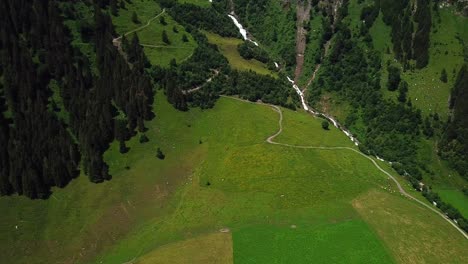 Aerial-shot-of-Walcherfall-waterfall,-Ferleiten,-Austria,-flowing-down-near-a-mountain-trail