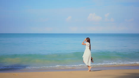 Beautiful-girl-walks-on-seashore-dressed-in-white