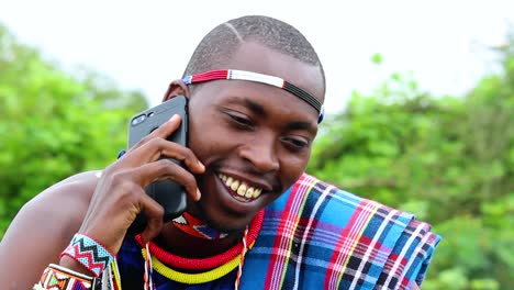 Glücklicher-Afrikanischer-Mann,-Lächelnd,-Telefonierend,-Traditionelle-Masai-kleidung-Tragend