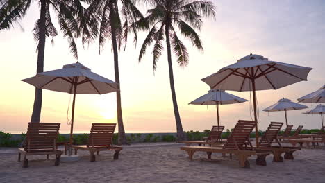 Leere-Betten-Und-Sonnenschirme-Am-Sandstrand-Des-Luxuriösen-Tropischen-Resorts-Bei-Sonnenuntergang,-Statische-Ansicht