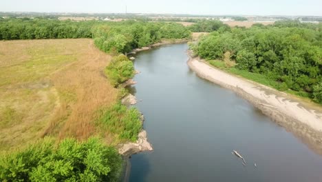Drone-aerial-view-of-following-the-Iowa-River-water-trail-and-several-logs-in-the-river