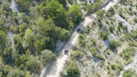 Aerial-of-buggy-cars-riding-on-rough-and-unpaved-terrain-amidst-barren-land
