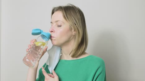 A-woman-has-to-remove-her-PPE-mask-before-she-can-drink-from-her-water-bottle