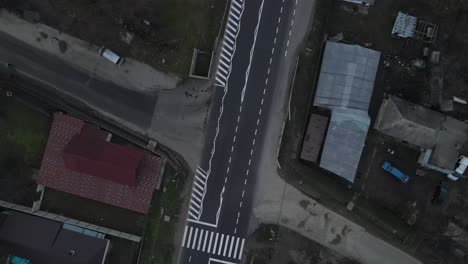 Vehicles-On-The-Asphalt-Road-With-Houses-Alongside-In-Vrancea-County,-Romania,-aerial-orbiting
