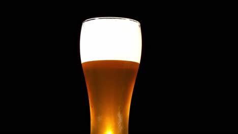Cerveza-Burbujeante-Fresca-Con-Espuma-En-Un-Vaso-Pilsner-Aislado-En-Fondo-Negro-Con-Humo---Foto-De-Estudio