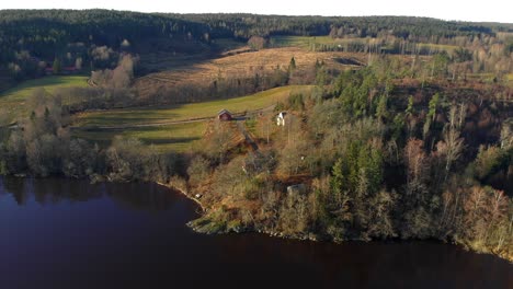 Luftaufnahme-Eines-Malerischen-Hauses-Auf-Einem-Bunten-Feld-In-Der-Nähe-Eines-Sees-Im-Herbst