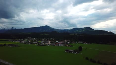 Drone-view-above-a-mountain-valley-and-a-stormy-cloudscape,-Oberndorf,-Austria