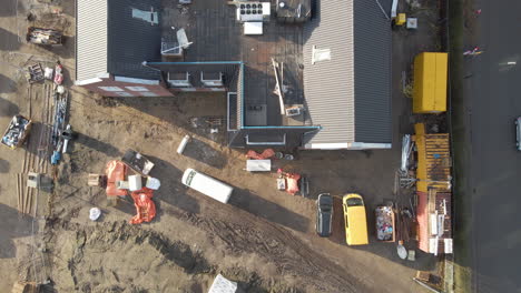 Top-down-aerial-of-busy-construction-site---drone-lifting-up
