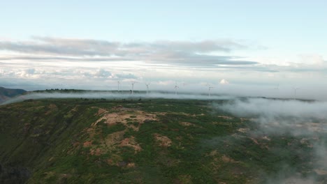 Aerial-in-middle-of-mountainous-Madeira-with-low-clouds-and-distant-windmills