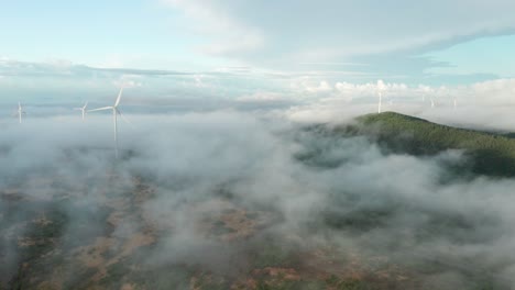 Magical-mist-flows-with-air-current-past-wind-turbines-at-high-altitude-park