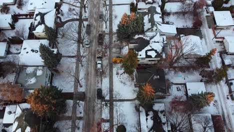 2-5-twilight-aerial-birds-eye-view-over-luxury-winter-residential-homes-snowed-in-roads-bare-trees-hardly-nobody-outside-accept-parked-cars-delivery-bikes-out-during-quiet-restriction-lockdown-COVID19