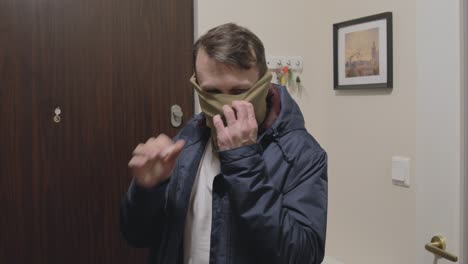 A-cautious-man-comes-home-and-takes-off-three-layers-of-masks-during-the-pandemic