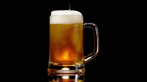 Verter-Cerveza-Lager-En-Una-Jarra-De-Cerveza-Con-Espuma-En-Fondo-Negro---Toma-De-Estudio