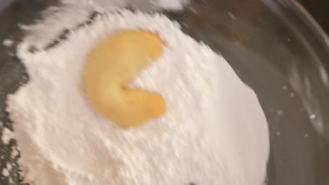 Making-Vanilakipferl-cookies,-coating-the-cookie-in-icing-sugar