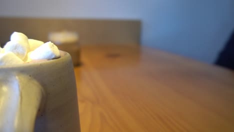 3-3-Bokeh-backgroud-at-coffee-shop-with-blurred-customers-seated-table-enjoying-hot-chocolate-with-marshmellows-iced-glass-jar-of-mocha-on-wooden-table-during-the-daytime-rotating-closeup-table-view