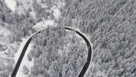 Curved-Road-in-Wintry-Snow-Mountain-Landscape-in-December,-Aerial