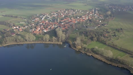 Drone-aerial-of-the-typical-german-village-Seeburg-located-at-the-Seeburger-See-on-a-beautiful-Sunday-morning