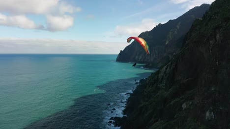 Extreme-paraglider-flies-close-to-shore-of-scenic-Madeira-island,-aerial