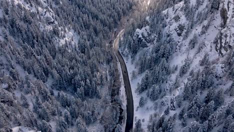 Winter-Scenery-Aerial-of-Road-in-Snowy,-Beautiful-Mountain-Valley