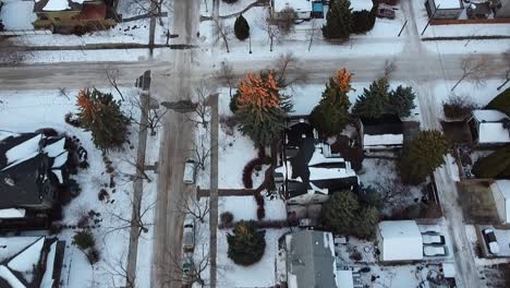 3-5-twilight-aerial-birds-eye-view-over-luxury-winter-residential-homes-snowed-in-roads-bare-trees-hardly-nobody-outside-accept-parked-cars-delivery-bikes-out-during-quiet-restriction-lockdown-COVID19