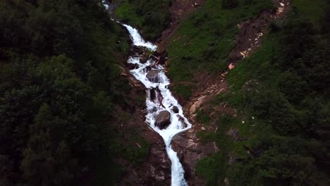 Aerial-view-of-Walcherfall-waterfall,-Ferleiten,-Austria,-flowing-down-through-a-forest