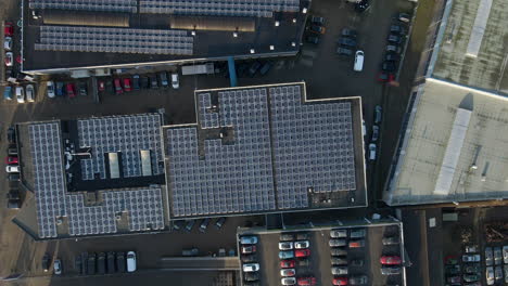 Top-down-aerial-of-industrial-building-rooftop-filled-with-solar-panels