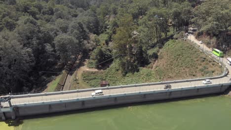 Cars-driving-across-barrage-dam,-Munnar,-India