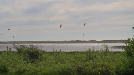 Kitesurfers-Sailing-With-The-Wind-At-Floras-Lake-In-Oregon---wide-shot,-slow-motion