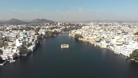 4k-aerial-footage-of-a-water-channel-off-of-Lake-Pichola-running-through-the-exotic-city-of-Udaipur,-India