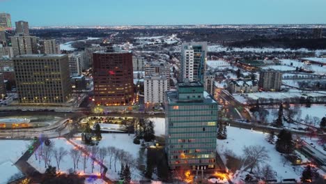 2-3-aerial-flyer-over-evening-winter-festive-city-riverside-historic-hometown-park-skyline-forest-nature-sleigh-bells-Christmas-lights-on-buildings-trees-walkways-subway-system-underground-city-paths
